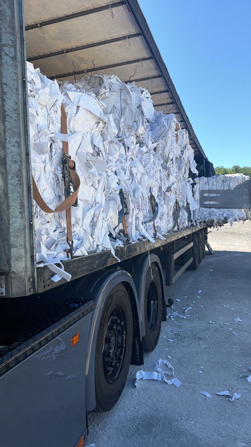 Balen oud papier in een vrachtwagen